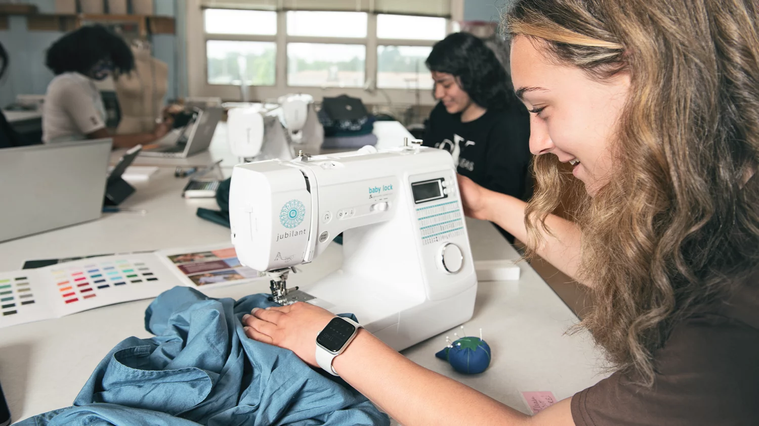 girl sewing blue fabric